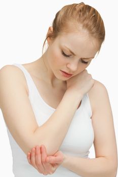 Woman touching her painful elbow against white background