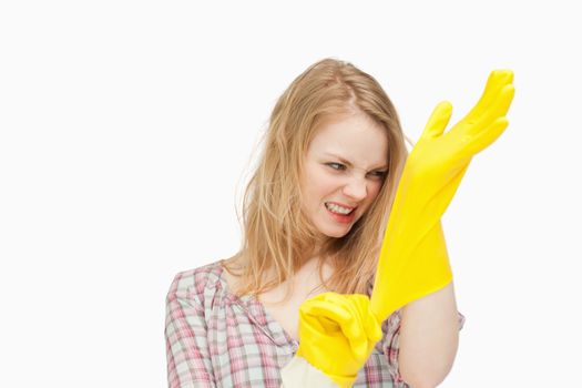 Angry woman wearing cleaning cloves against white background