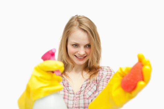 Woman holding cleaning products against white background