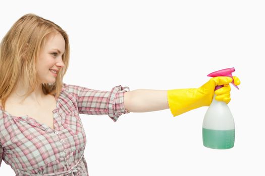 Blond-haired woman holding a spray bottle against white background