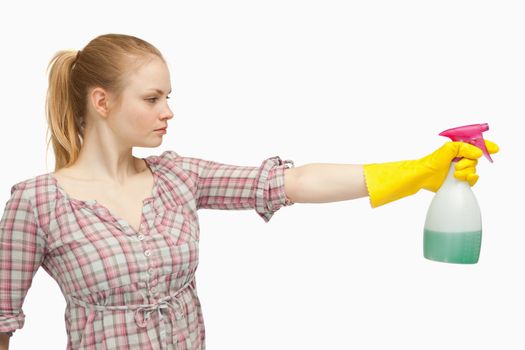 Joyful woman holding a spray bottle against white background