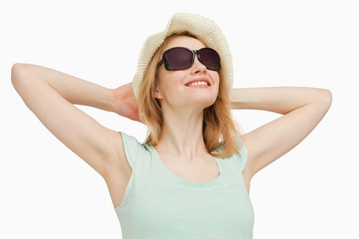 Woman wearing a summer hat while smiling against white background
