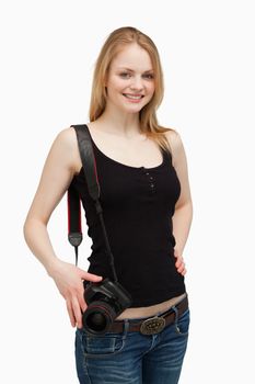 Woman smiling while carrying a camera against white background