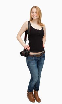 Cheerful woman holding a camera against white background