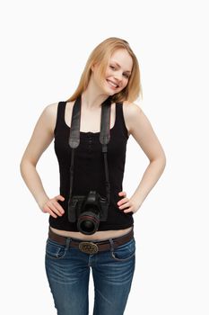 Smiling woman carrying a camera against white background