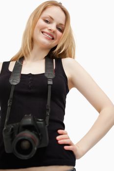 Joyful woman holding a camera against white background