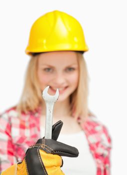 Woman holding a wrench against white background