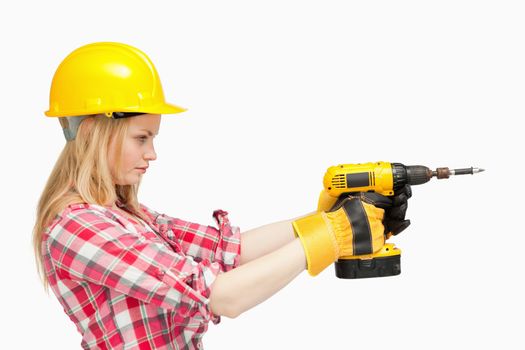 Serious woman using an electric screwdriver against white background