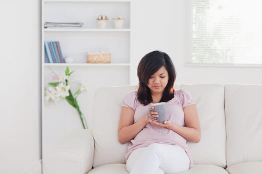 Woman relaxing as she sits on a sofa in a living room