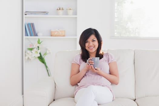 Smiling woman sitting on a sofa in a living room