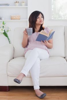 Woman drinking from a mug in a living room