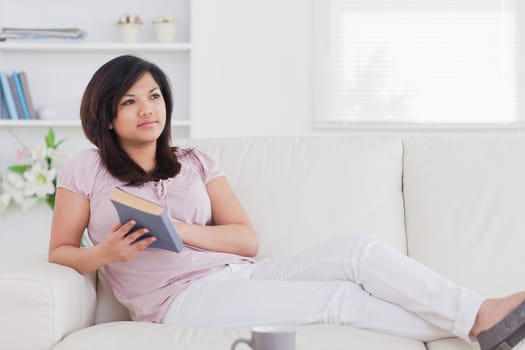 Woman relaxing while lying on a sofa in a living room