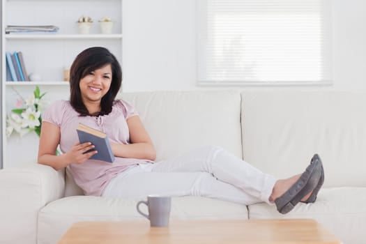 Smiling woman lying on a sofa in a living room