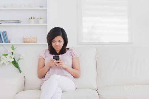 Woman holding a phone while sitting on a couch