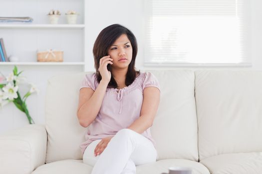 Woman sitting on a couch holding a phone in a living room