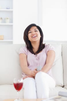 Woman laughing while sitting on a sofa in a living room