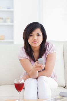 Woman sitting on a couch holding a remote in a living room