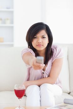Woman looking at television while she sits on a couch in a living room