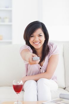 Woman smiling and holding a television remote in a living room