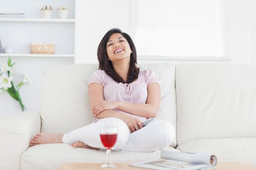 Woman laughing while resting on a sofa in a living room