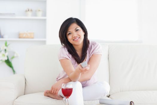 Woman sitting on a couch and holding a television in a living room