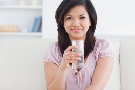 Woman holding a glass of water in a living room