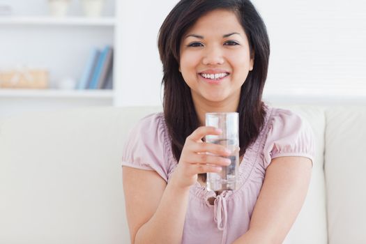 Woman holding a glass full of water in a living room