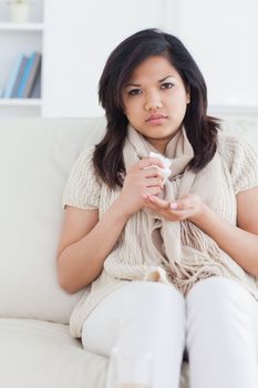 Sick woman sitting on a couch in a living room