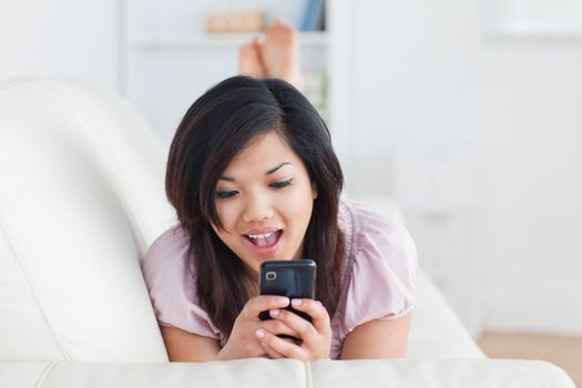 Woman resting on a couch and holding a phone in a living room