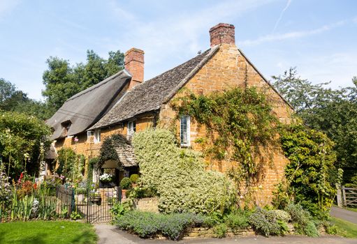 Ancient cotswold stone house and flower garden in Cotswold village of Ilmington