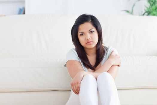 Woman sitting in front of a coach in a living room