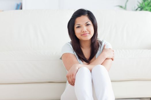 Smiling woman sitting on the floor in a living room