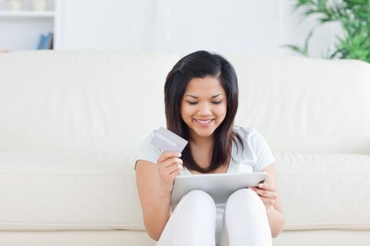 Woman sitting on the floor in front of a sofa in a living room