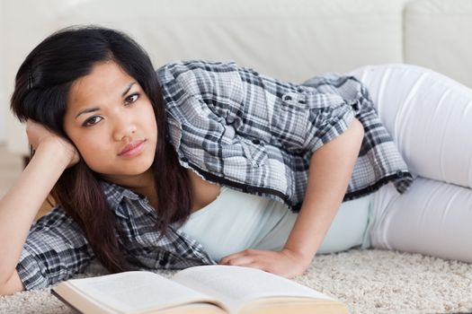 Woman on the floor holding her head with her hand in a living room