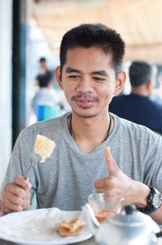 asian man enjoy eating breakfast