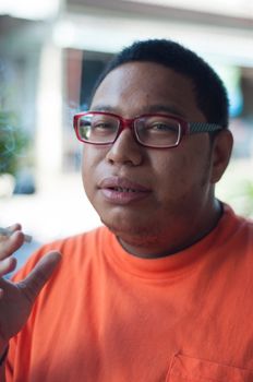 asian man wearing glasses smoking cigarette