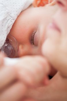 Baby sleeping while sucking a pacifier indoors