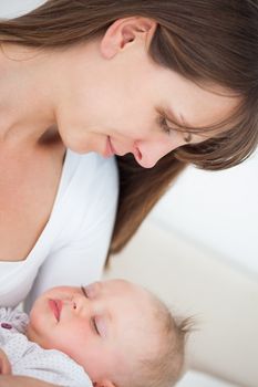 Peaceful brunette woman holding her little daughter indoors
