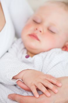 Peaceful baby being held by her mother in a room