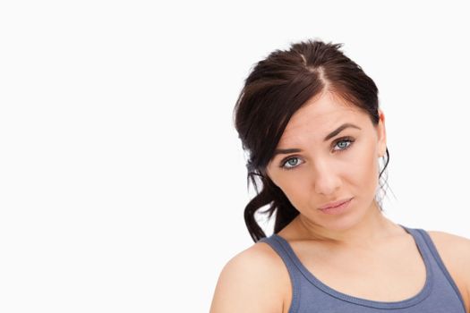 Unhappy young woman looking at camera against white background