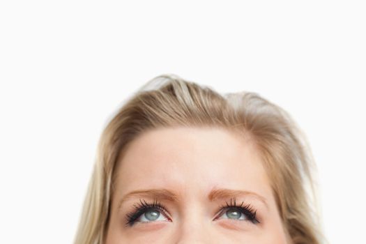 Cheerful blonde woman looking up against a white background