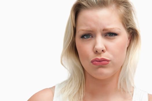 Upset blonde woman staring at the camera against a white background