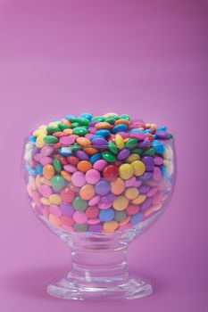 A bunch of chocolate buttons, in various colors such as pink, purple and yellow.