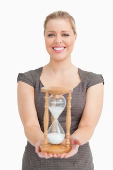 Woman showing a hourglass against white background