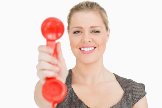 Retro phone red in a hand of a pretty woman against white background