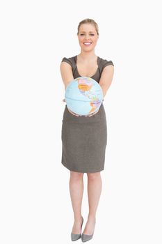Woman smiling showing a globe against white background
