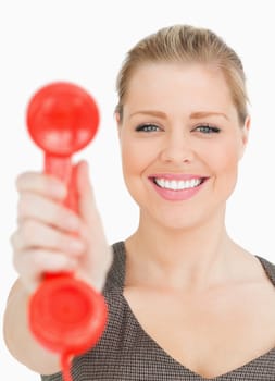 Woman smiling showing a retro phone against white background