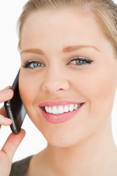 Woman smiling calling with her smartphone against white background
