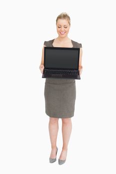 Businesswoman showing a laptop against white background