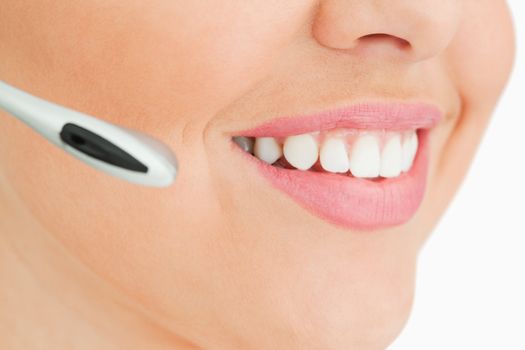 Close-up of a woman smiling working in call center against white background